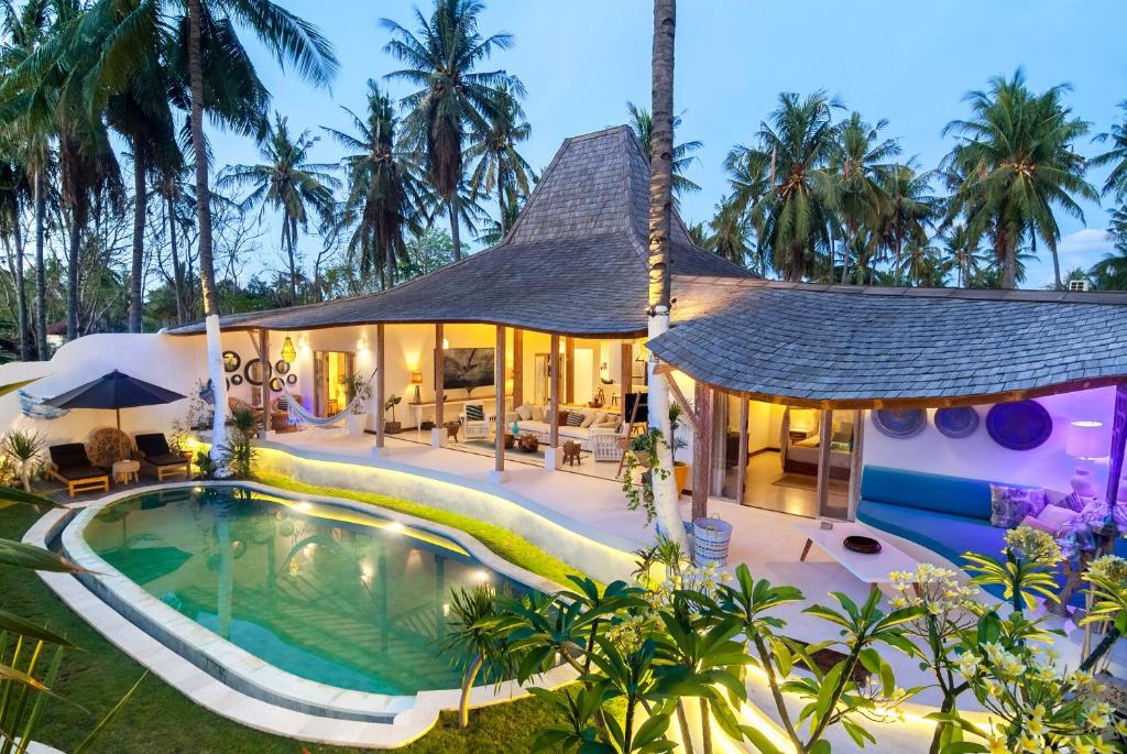 an exterior view of a villa with a swimming pool at De'Coco Villa in Gili Islands