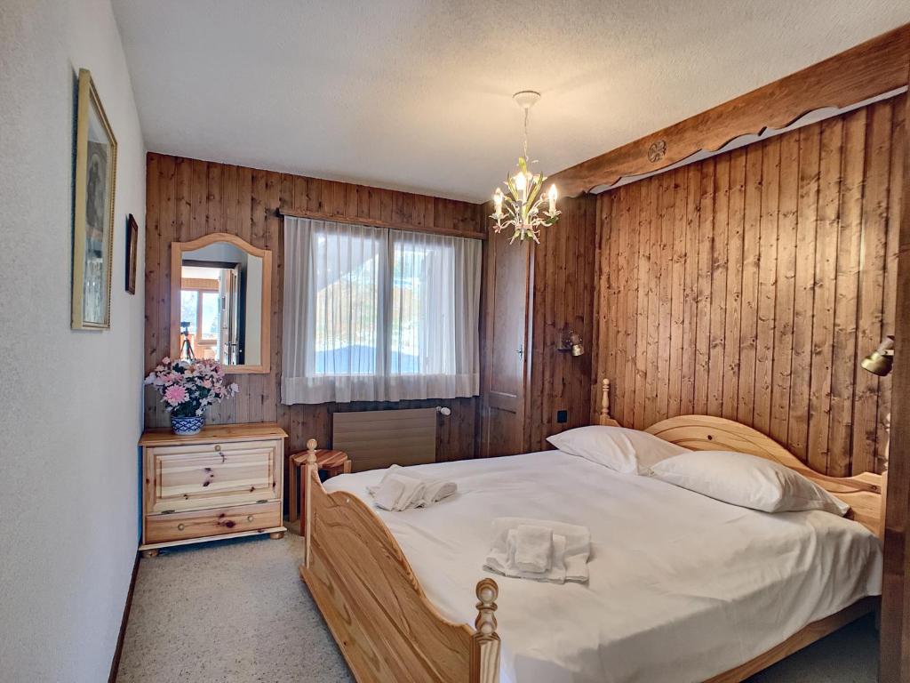ヴェルビエにあるApartment Mandarin 118Bisの大きなベッドと木製の壁が備わるベッドルーム1室が備わります。
