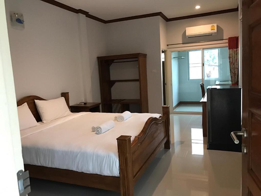 a bedroom with a bed with two towels on it at Suksopha Resort in Prachuap Khiri Khan