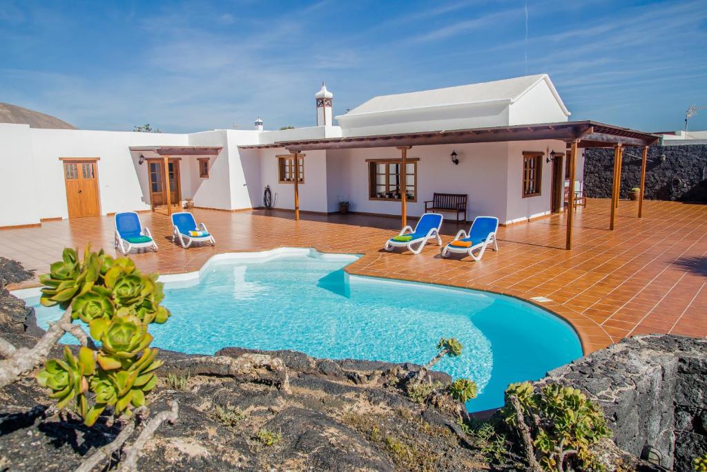 een villa met een zwembad en een huis bij Casa Lola Lanzarote piscina climatizada y wifi free in San Bartolomé
