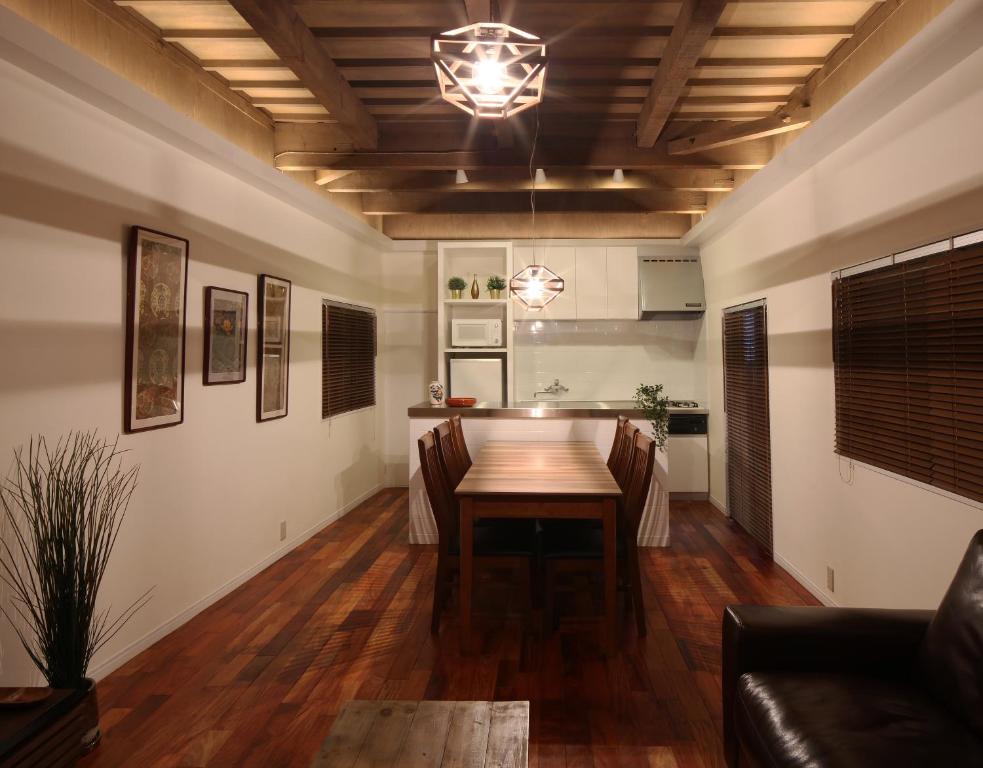 een eetkamer met een tafel en een bank bij Chikyuutabikazoku USJ in Osaka