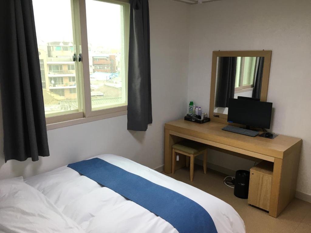 Postel nebo postele na pokoji v ubytování Hotel Joy near Camp Humphres