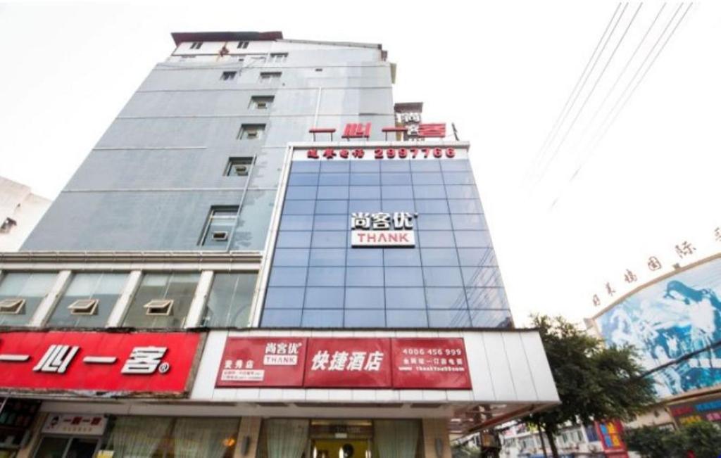 een hoog gebouw met een bord erop bij Thank Inn Chain Hotel Sichuan Nanchong in Nanchong