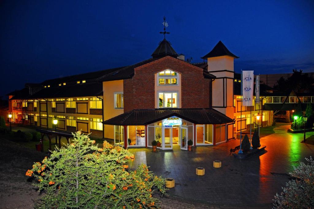 un gran edificio de ladrillo por la noche en Hotel Aqua Panon, en Kanjiža