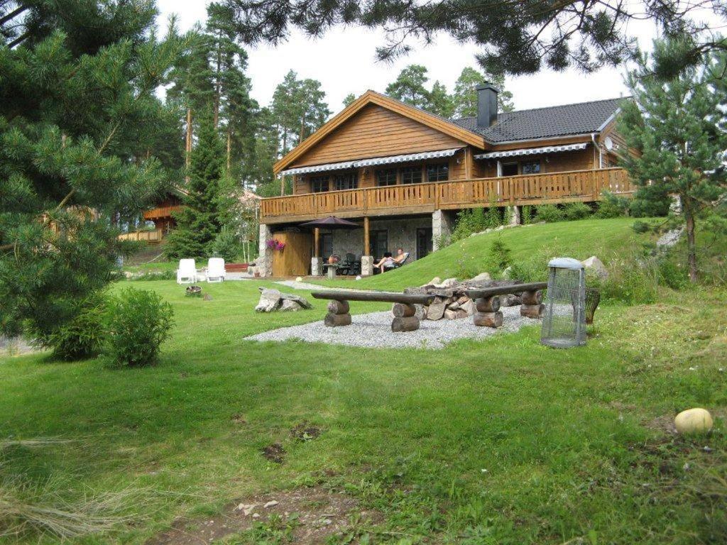 una cabaña de madera con un banco delante en Glafsfjordens Accommodatie, en Arvika