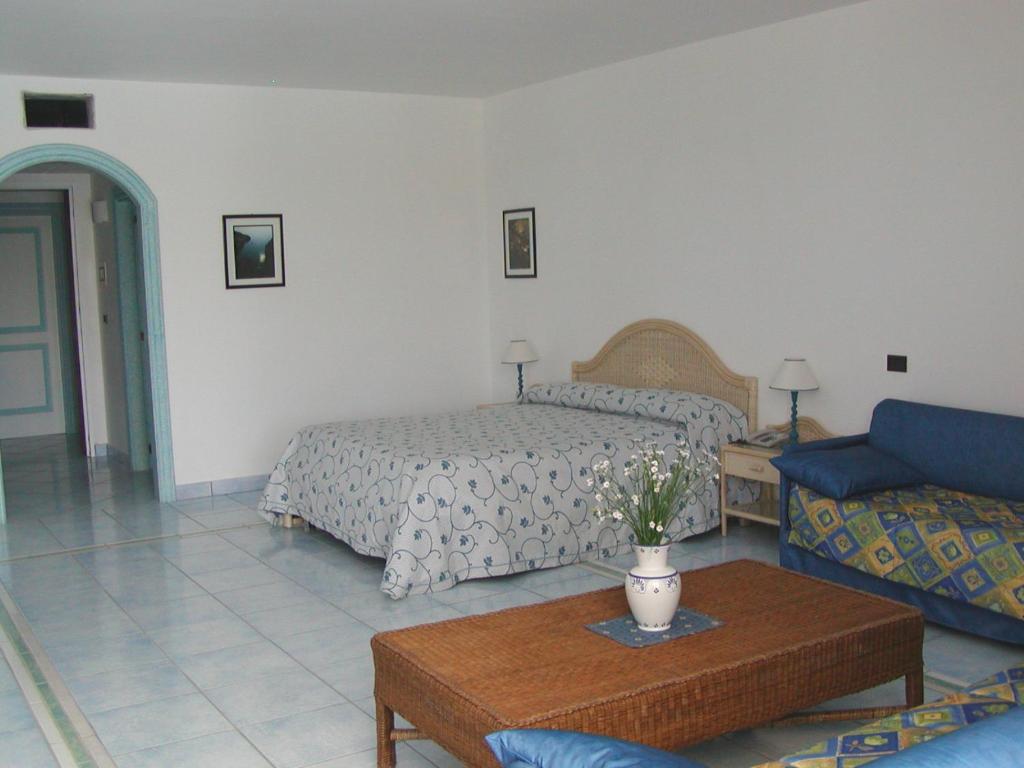 a bedroom with a bed and a couch and a table at Hotel Selenia Residence in Castro di Lecce