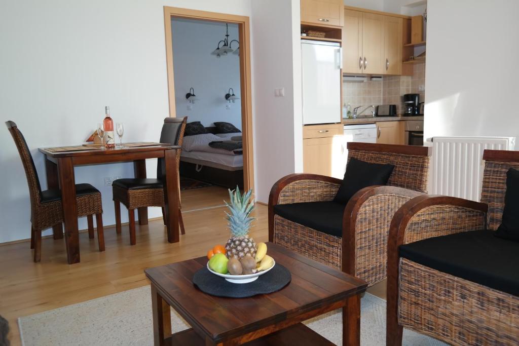 a living room with a table with a bowl of fruit on it at Aramis 3 Apartments in Hévíz