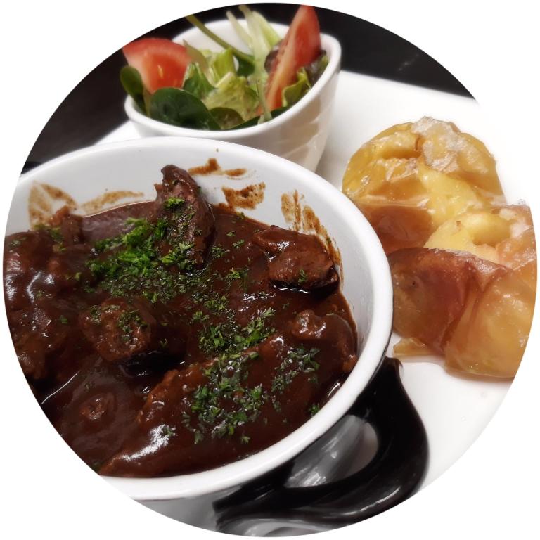 a plate of food with a bowl of meat and a salad at Boat Hotel De Barge in Bruges