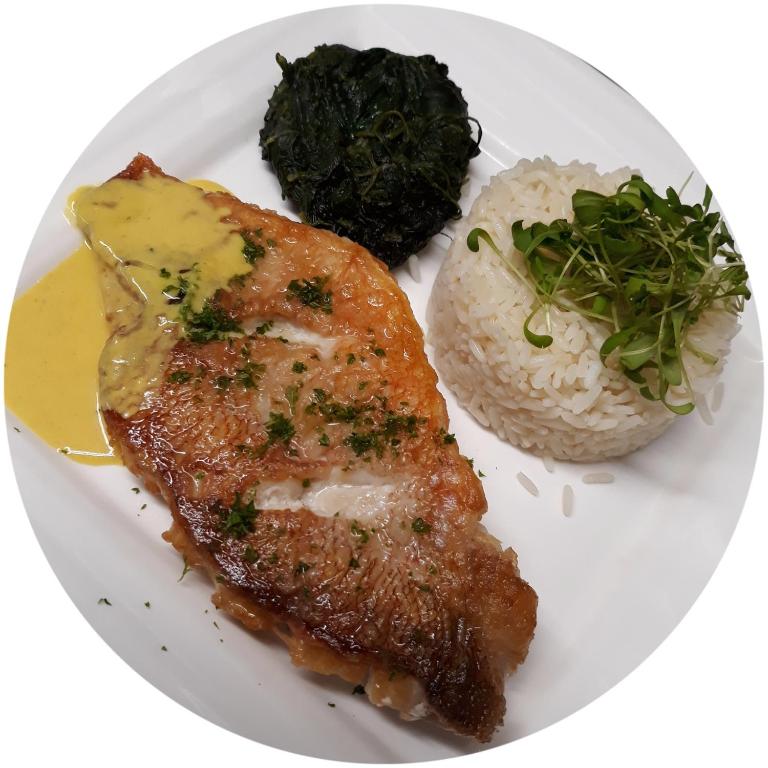 a plate of food with meat and rice and broccoli at Boat Hotel De Barge in Bruges