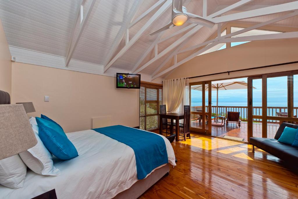 a bedroom with a bed and a view of the ocean at Aquamarine Guest House in Mossel Bay