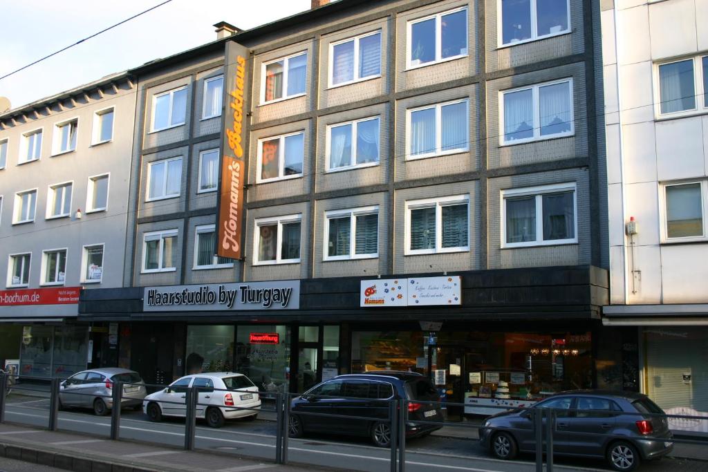 een gebouw in een straat waar auto's voor geparkeerd staan bij Atrium City in Bochum