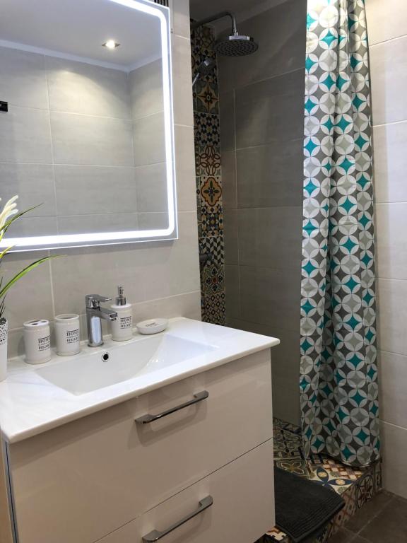 W łazience znajduje się umywalka, lustro i prysznic. w obiekcie Yumbo Apartments w mieście Maspalomas