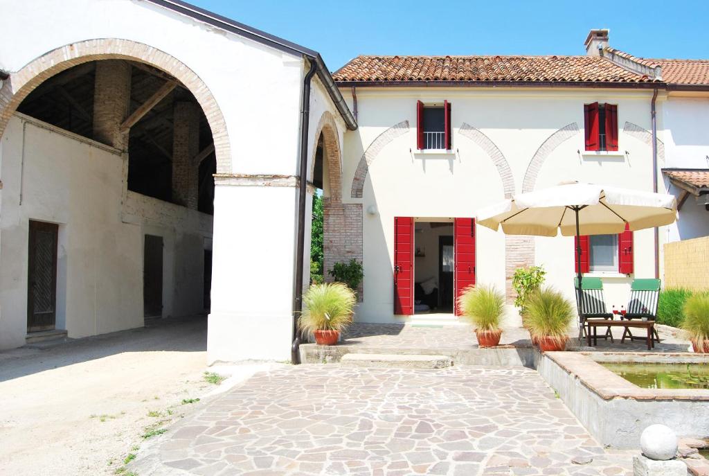 een wit gebouw met een paraplu en een patio bij Burro e Marmellata in Sabbioncello