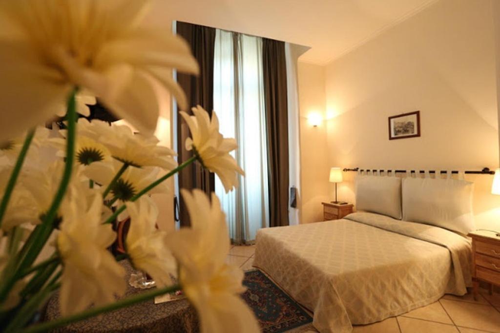a hotel room with a bed and flowers in the foreground at Bovio Suite in Naples