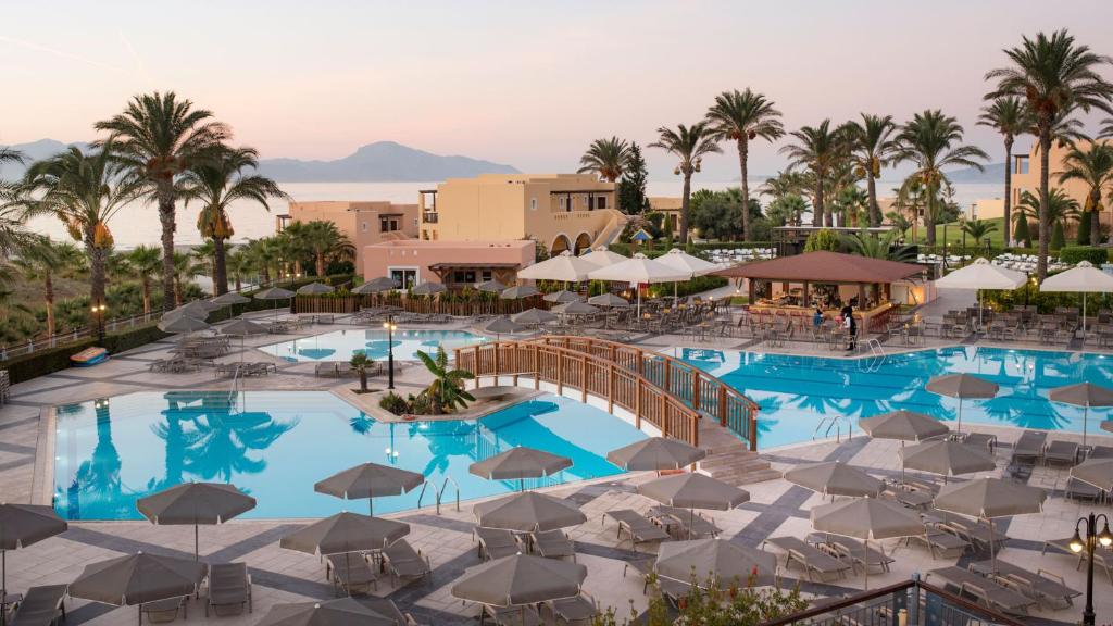 una vista aérea de una piscina del complejo con sillas y sombrillas en Horizon Beach Resort en Mastichari