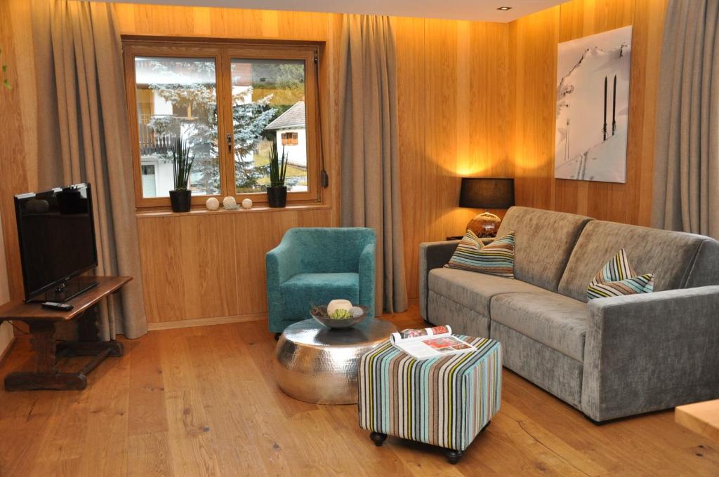 a living room with a couch and a chair at Appart Weißschrofenspitze in Sankt Anton am Arlberg