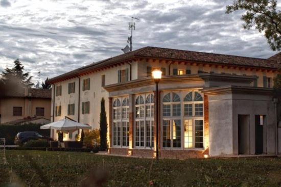 un gran edificio con una luz encendida delante de él en Agriturismo Villa Trovatore, en Cervignano del Friuli
