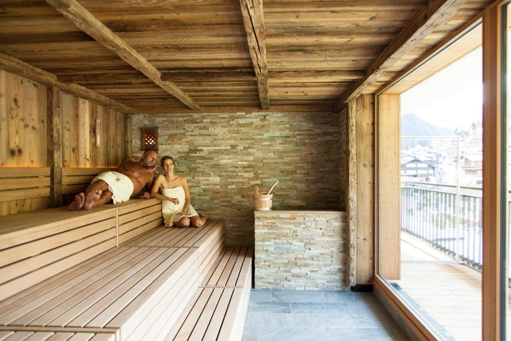 a man and a woman sitting in a sauna at Anthony's Life&Style Hotel in Sankt Anton am Arlberg