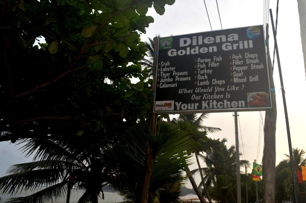 a sign for a golden grill on a street at Dilena Beach Inn in Tangalle
