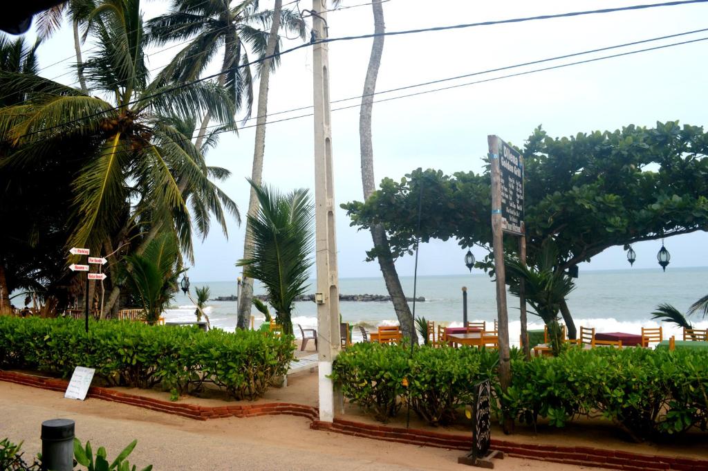 a view of a beach with palm trees and the ocean at Dilena Beach Inn in Tangalle