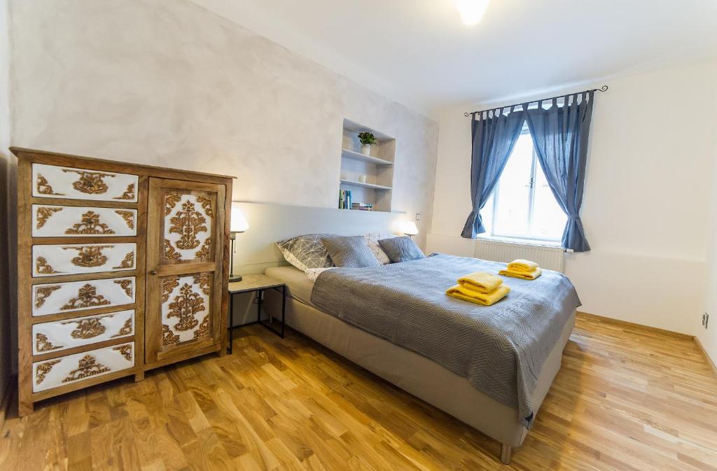 Un dormitorio con una cama grande y una ventana en Babylon Apartmány en Český Krumlov
