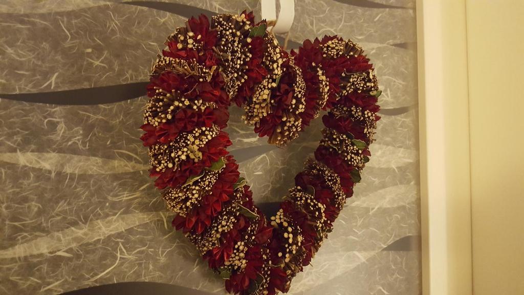 a red heart shaped wreath on a wall at Casa Mafalda in Chioggia