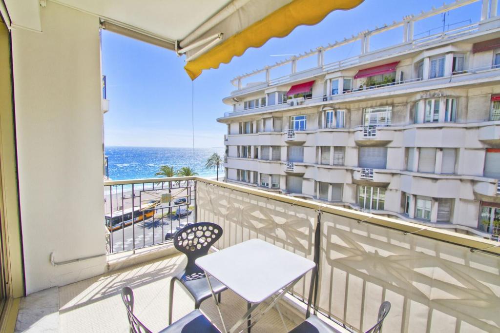 uma varanda com mesa e cadeiras e vista para o oceano em PROMENADE HOLIDAY - PALATIN & SEA em Nice