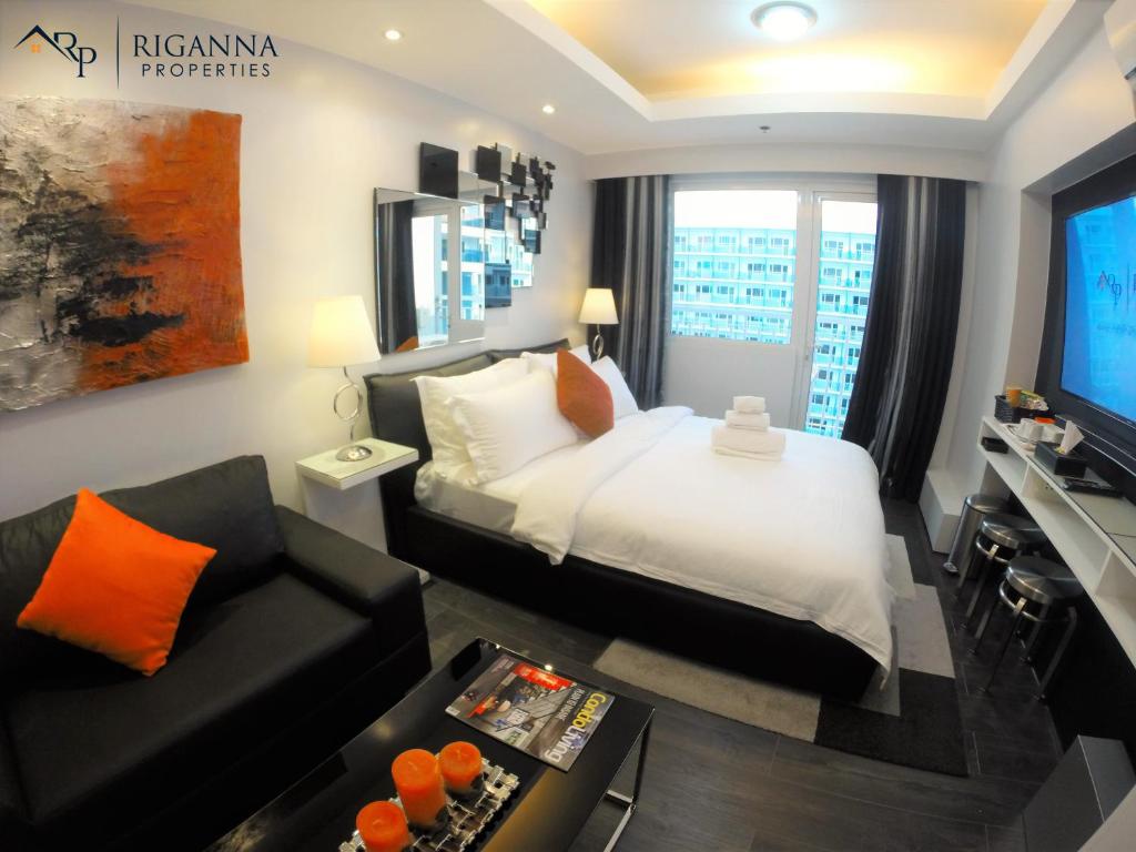 a hotel room with a bed and a couch at Riganna Two @ Shell Residences - near Airport, MOA in Manila