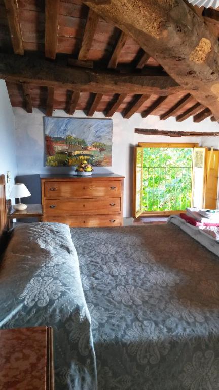 a bedroom with a bed and a dresser and a window at Azienda Agricola Fabbrica Di San Martino in Lucca