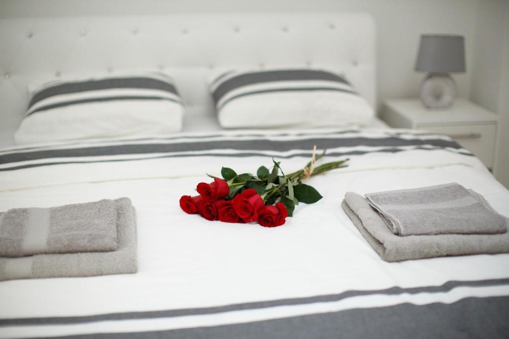 un montón de rosas rojas sentadas en una cama en Apartman Centar en Banja Luka