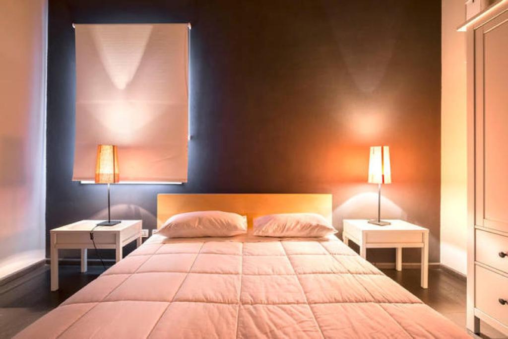 ボローニャにあるDowntown Luxury Apartmentのベッドルーム1室(大型ベッド1台、ナイトスタンド2台付)