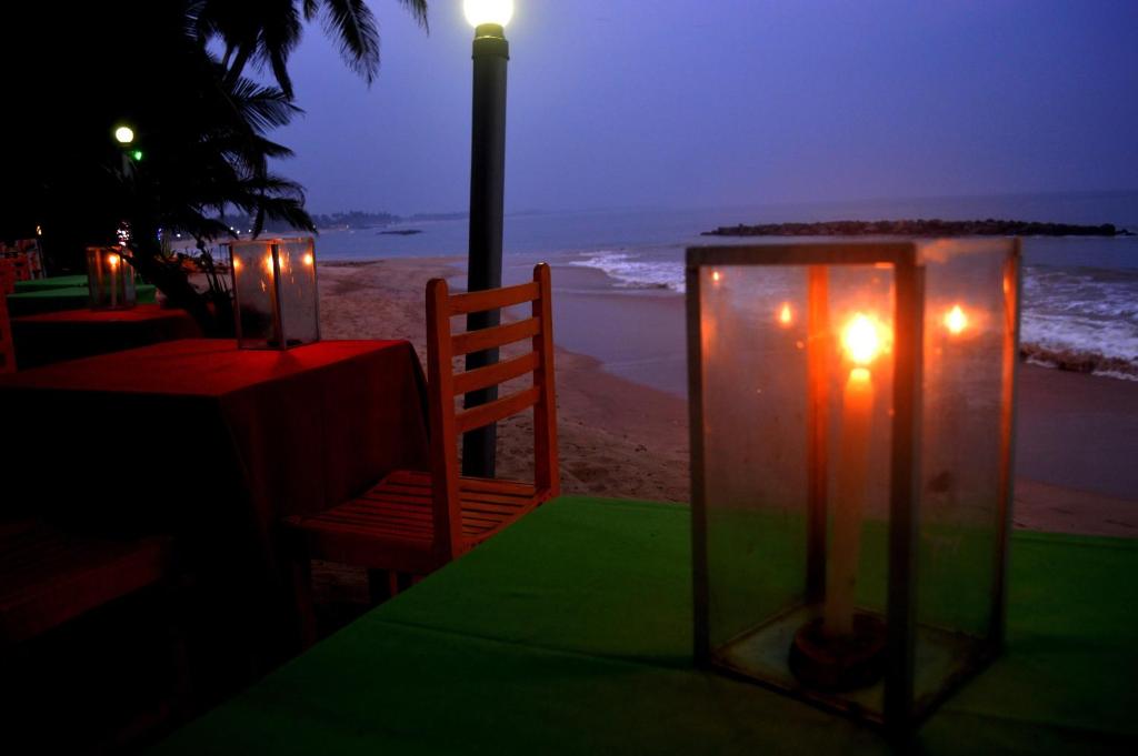 a table with candles and a table on the beach at Dilena Beach Inn in Tangalle