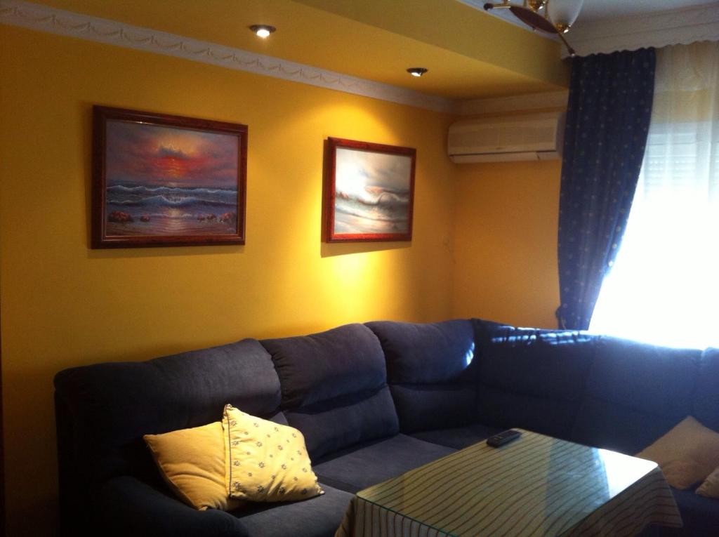 Casa Bahía de Cádiz في بويرتو ريال: غرفة معيشة مع أريكة زرقاء وطاولة