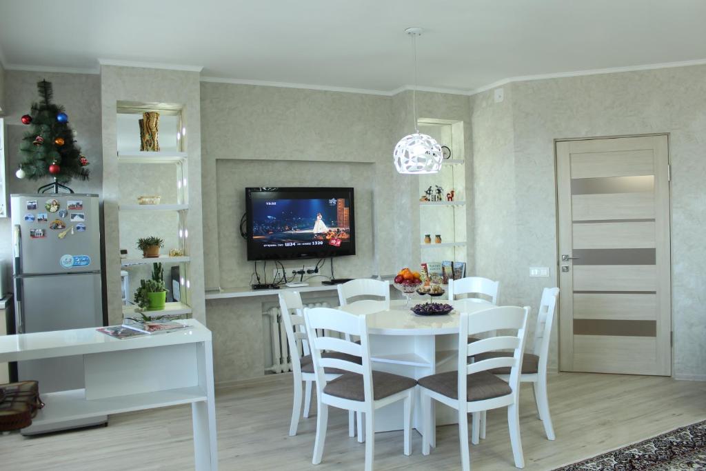 a kitchen and dining room with a white table and chairs at Apartment in the Karakol heart in Karakol