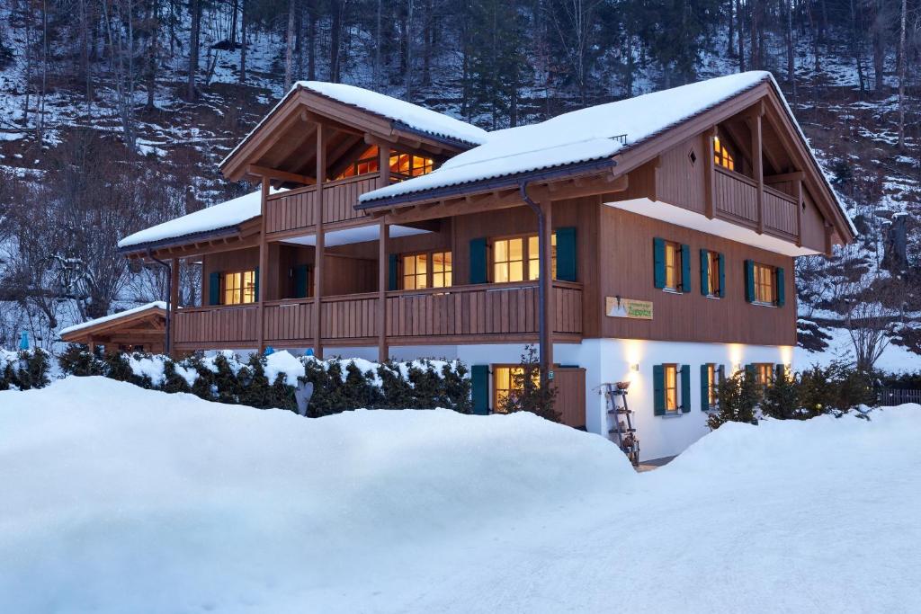 une maison recouverte de neige dans la neige dans l'établissement Ferienwohnungen Zugspitze, à Grainau