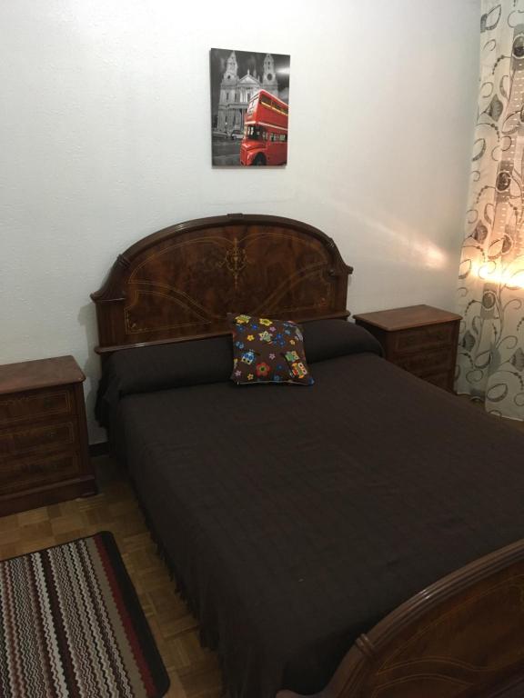 アランダ・デ・ドゥエロにあるCalidad En Pleno Centro De Arandaのベッドルーム1室(木製ベッド1台、枕付)