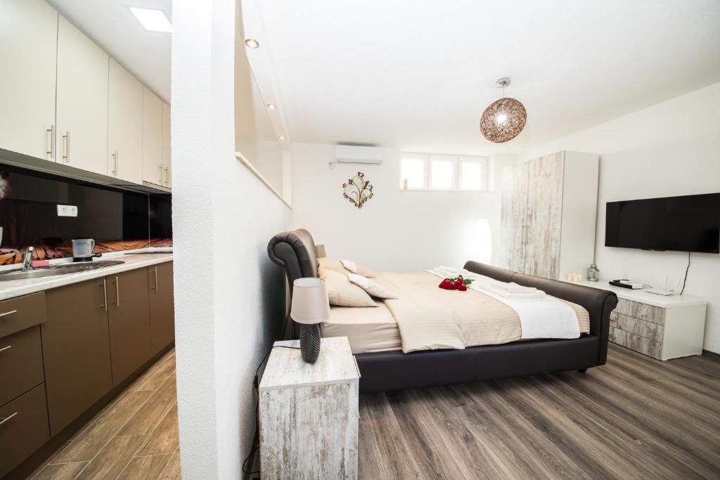 a bedroom with a large bed and a kitchen at Studio apartman Centar in Banja Luka