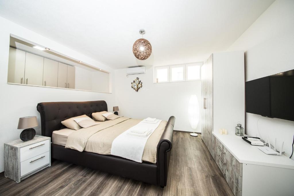 a bedroom with a large bed and a desk at Studio apartman Centar in Banja Luka