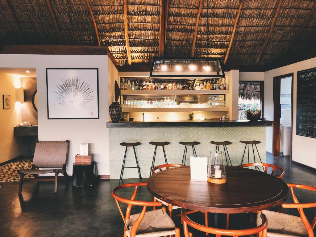 um restaurante com mesa e cadeiras e um bar em Malibu Popoyo em Popoyo
