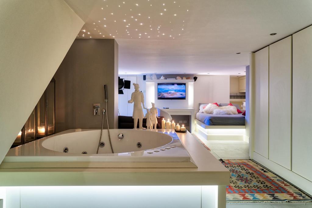 a bathroom with a tub and a bedroom with a bed at Luxury eden in Catania