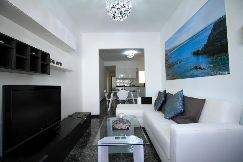 a living room with a white couch and a tv at Cotillo Sea in Cotillo