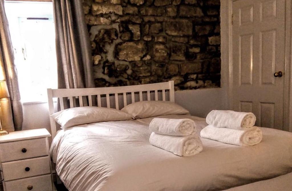 a bedroom with a bed with towels on it at The George & Dragon Felton in Felton