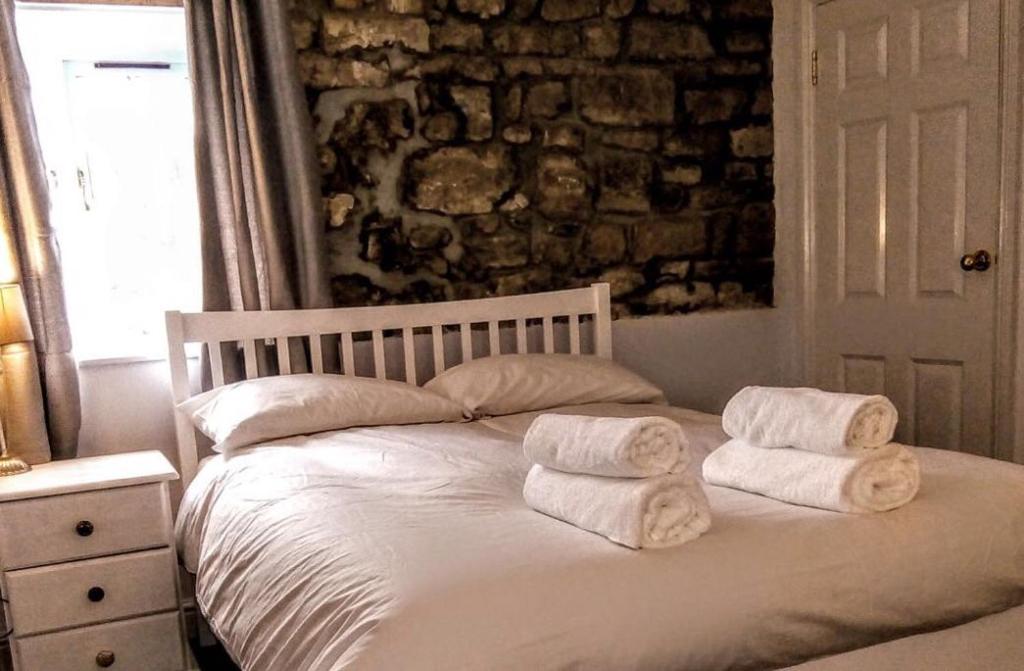 una camera da letto con un letto e asciugamani di The George & Dragon a Felton