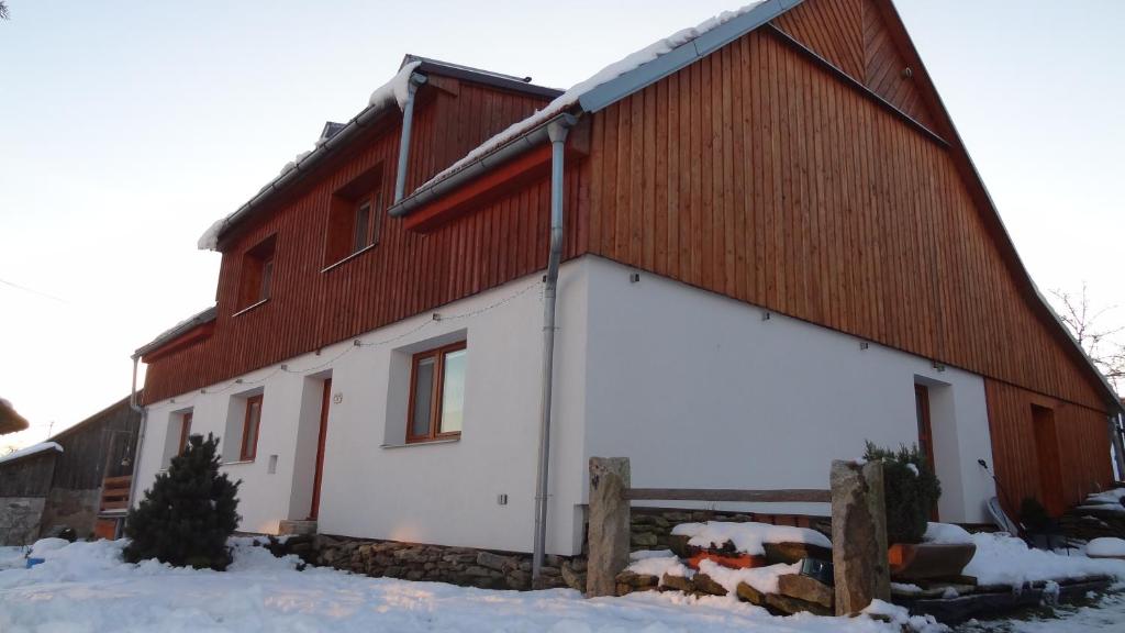 un fienile rosso e bianco nella neve di Ubytování U Kapličky a Nové Město na Moravě