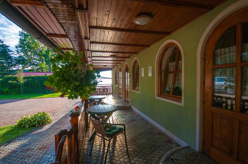 a porch of a building with a table and chairs at Apartmány pri zámočku in Bešeňová