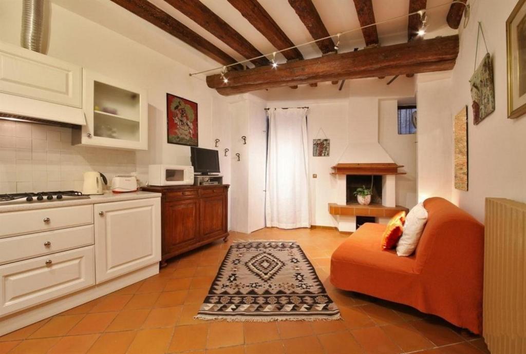 a living room with an orange couch and a kitchen at Ca Lucia in Venice
