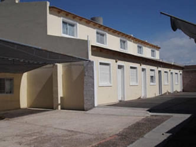 un gran edificio blanco con un garaje delante en Amaneceres Las Grutas en Las Grutas