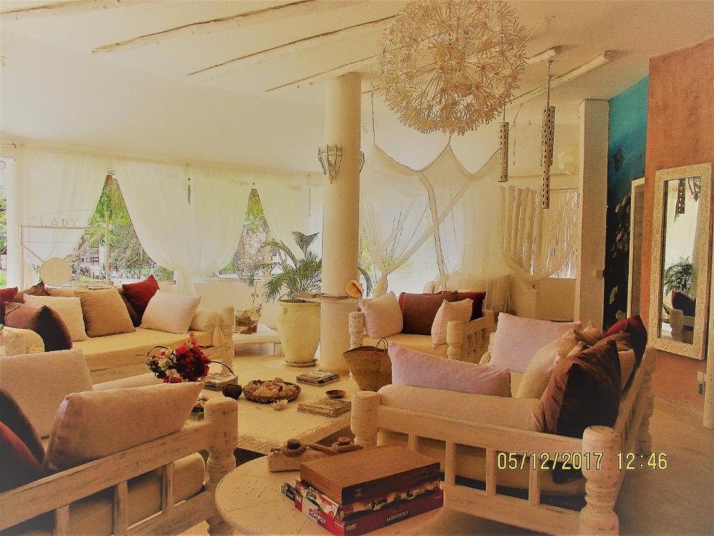 a living room with couches and a chandelier at Lady D House in Watamu