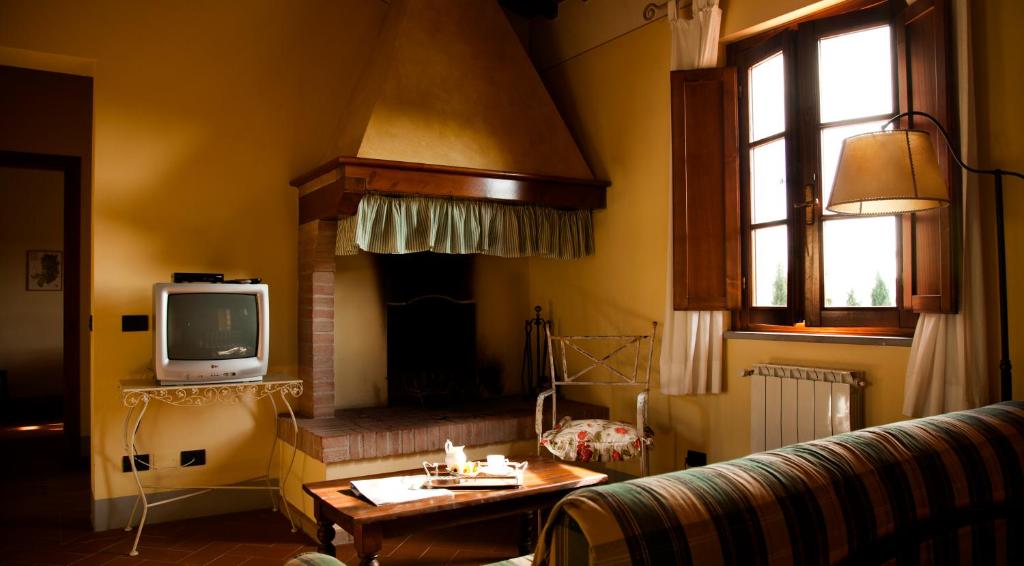 salon z kanapą i telewizorem w obiekcie Agriturismo Fattoria Rozzalupi w mieście Cerreto Guidi