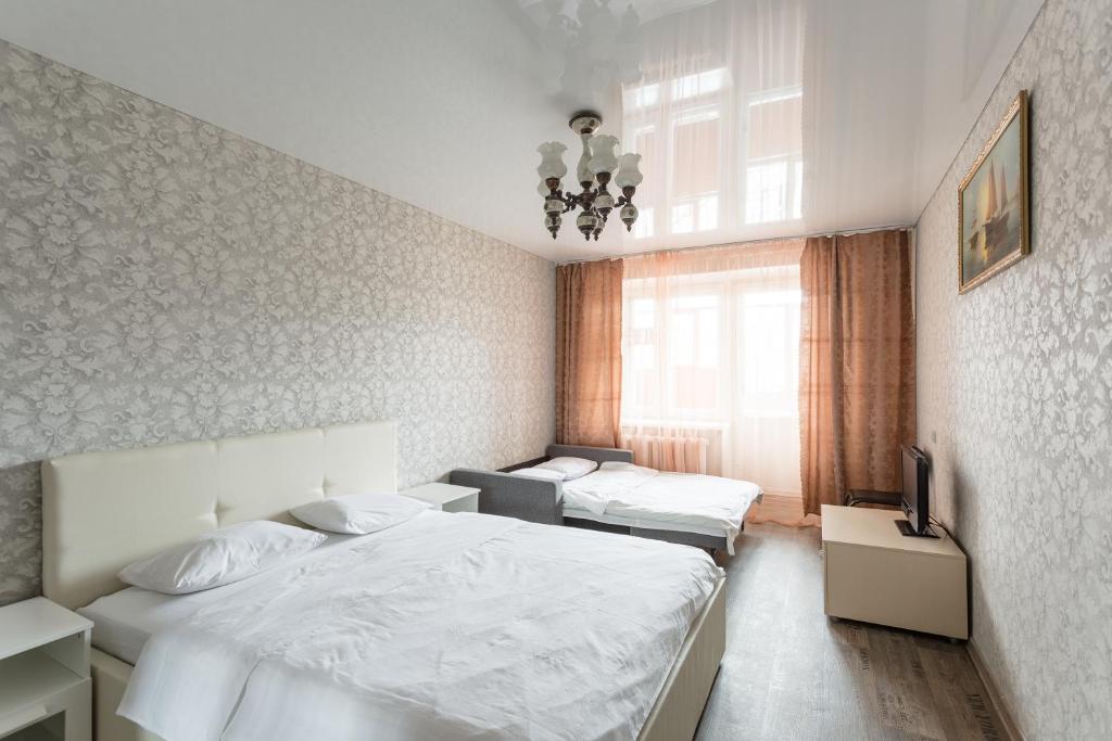 1 dormitorio con 2 camas y ventana en Хочу Приехать на улице Чехова, en Vólogda